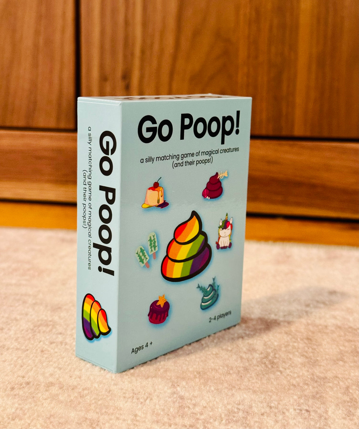 blue Go Poop game box against wood background- showing small card game 